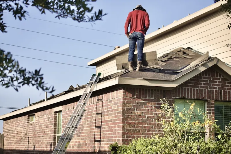 Professional roofer working on a residential roof in Altmar